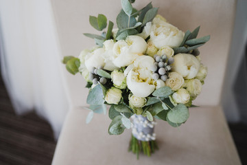 Beautiful modern bridal bouquet of colorful fresh flowers with sikl ribbons. Classic wedding traditional accessory.