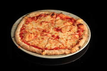 whole sliced four cheese pizza isolated on black background