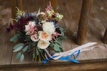 Beautiful modern bridal bouquet of colorful fresh flowers with sikl ribbons. Classic wedding...