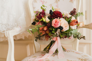 Beautiful modern bridal bouquet of colorful fresh flowers with sikl ribbons. Classic wedding traditional accessory.