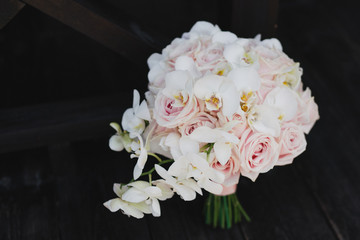 Beautiful modern bridal bouquet of colorful fresh flowers with sikl ribbons. Classic wedding traditional accessory.