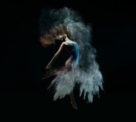 Female dancer jumping in cloud of dust