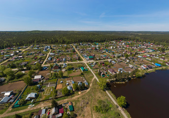 Obraz premium A pond in the Kamenka village, a dam and road. Sunny, summer, Aerial