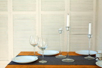 a set of two glasses and plates on the table on a light background in the room
