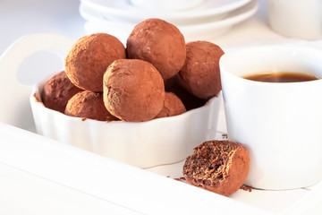 Homemade vegan chocolate truffles white plate morning light. Healthy tasty diet sweets concept