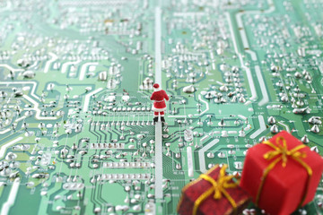 パソコンの基盤の上でクリスマスプレゼントを配るサンタクロース