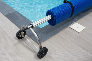 Pool cover blue bubble solar on the edge of swimming pool