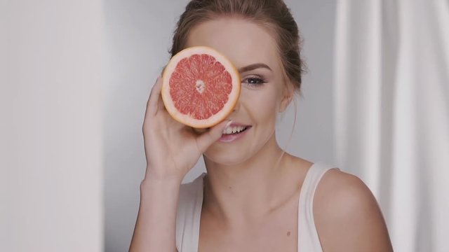pretty girl with pomelo giving kiss and laughs to the camera