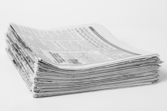 Pile of old newspapers on white background. Black and white photo