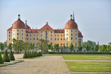 Fototapeta na wymiar The beautiful medieval castle of Moritzburg in the early morning in Germany. Moritzburg Baroque palace with yellow walls and a red roof. Traveling concept background. Moritzburg built in 16tn century 