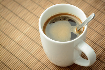 Aromatic tasty coffee in a cup against a brown background. Refreshing.