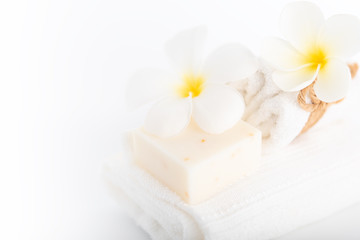 White towels,organic soap and Plumeria flower over white background,spa concept