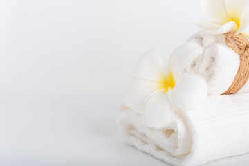 Fototapeta na wymiar White rolled towels decorate with Frangipani flowers spa object on white background