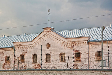 Criminal prison, white building with grilles and iron fences. Latvia, Daugavpils, 2019.