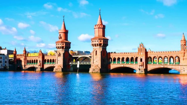 Berlin, Germany. View of Oberbaum bridge - a double-deck bridge over River Spree in Berlin, Germany during the sunny day in spring. Time-lapse with cloudy sky