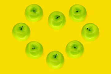 heart of apples or green apples heart on yellow background with copy space.