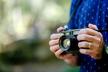 Hand and camera of the photographer Travel in the mountains and nature Concept photographer