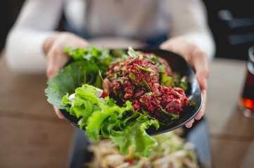Hand and fresh meat, food of people who like to eat fresh meat, raw food, eating food concepts