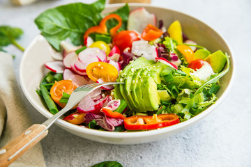 Fresh vegetable salad bowl closeup, healthy organic vegetables salad with radish, spinach, tomatoes, onion, avocado - 271769345