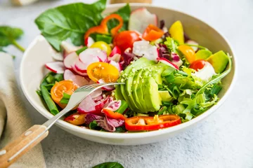 Foto auf Alu-Dibond Fresh vegetable salad bowl closeup, healthy organic vegetables salad with radish, spinach, tomatoes, onion, avocado © marrakeshh