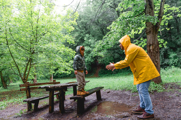 Naklejka na ściany i meble Having fun with my Dad on a rainy day in a park 