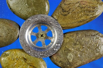 Water drain on smooth sea stones of natural origin and water droplets. Water drain and wet sea stones.