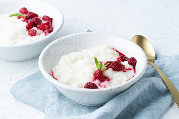 Rice pudding, side view. Healthy Vegan diet breakfast with coconut milk, raspberry, scandinavian minimalism