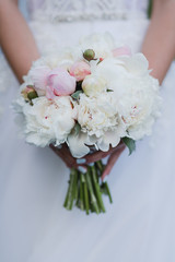 Modern bridal style. Closeup of caucasian bride holding a beautiful bouquet of colorful fresh flowers in her hands.