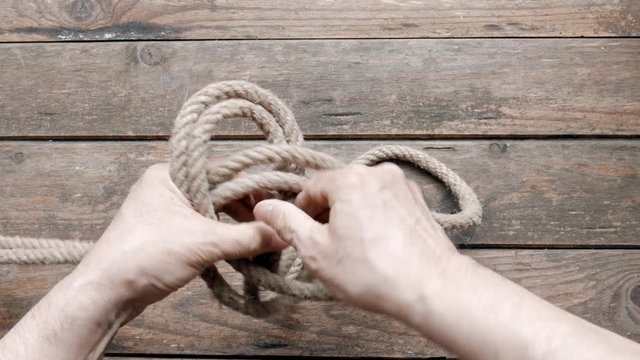 man making a knot in a rope