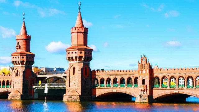 Berlin, Germany. View of Oberbaum bridge - a double-deck bridge over River Spree in Berlin, Germany during the sunny day in spring. Time-lapse with cloudy sky, panning video