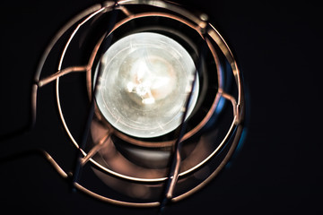 A vintage lantern with an illuminated light bulb.