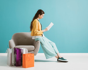 Woman shopping and reading a fashion magazine