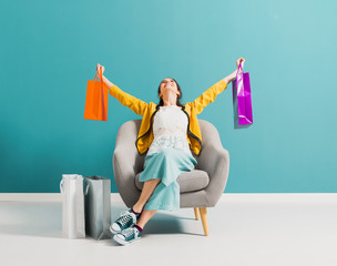 Cheerful shopaholic woman with shopping bags