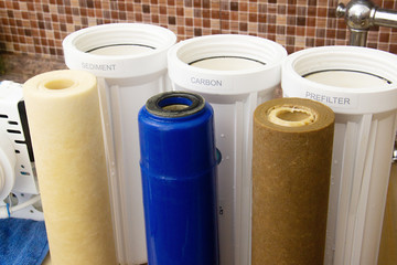 three dirty used osmosis water filter cartridges