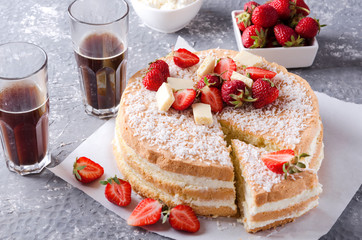 Piece of sponge cake, strawberries, glasses of hot coffee on the grey surface.Setting table for eating little snack