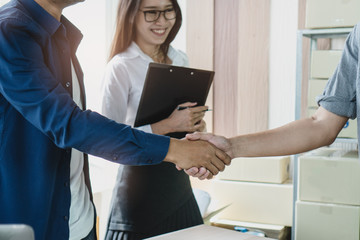 Businessman shaking hands with client in meeting after deal agreement.