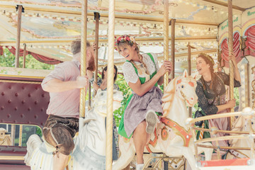 Gruppe von Freunden fährt mit dem Karussell auf dem Jahrmarkt Vergnügungspark