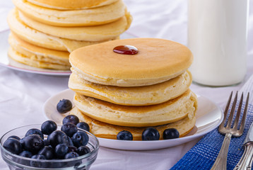 Nalesniki na sniadanie. Domowy posilek. Racuchy z jagodami i syropem klonowym. Nalesniki z dodatkami.