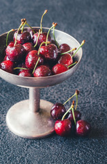 Fresh cherries in vintage silver vase