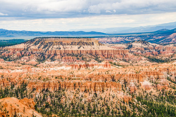 Hoodoos with pine trees and storm clouds at Bryce Canyon National Park in Utah.