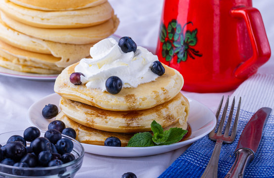 Nalesniki na sniadanie. Domowy posilek. Racuchy z jagodami i bita smietana. Nalesniki z dodatkami.