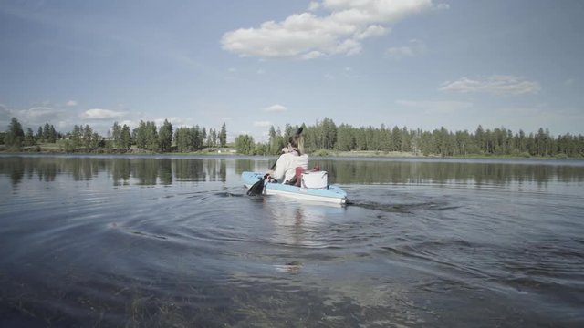 Woman rows away in a kayak on lake with view of shoreline