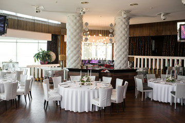 The wedding table setting for the newlyweds is decorated with fresh flowers of carnation, rose, anthurium and eucalyptus leaves. Silver candlesticks, white candles. Wedding floristry. Close-up details