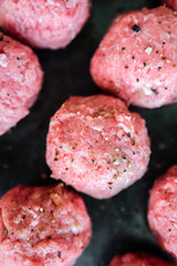 Raw uncooked meatballs on tray
