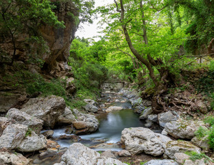 Naklejka na ściany i meble Gorge in the mountains of Crete, with a waterfall, river, stones and forest.