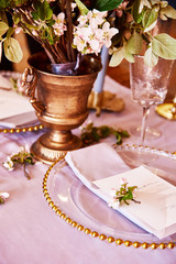 Festive table decor. Golden cutlery. With different natural colors and flowers. Garnet. Luxury wedding, party, birthday. View from above. Gold, pink. Candles