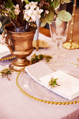 Festive table decor. Golden cutlery. With different natural colors and flowers. Garnet. Luxury wedding, party, birthday. View from above. Gold, pink. Candles