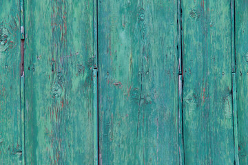 The background texture of the old fence of wooden natural boards painted with green paint. Cropped shot, horizontal, plenty of space. The concept of construction and design.