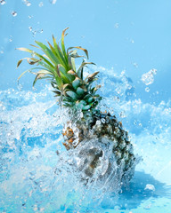 Pineapple in water splash on blue background