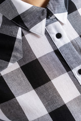 Black and white plaid shirt on buttons. Stitched collar closeup. Vertical background.